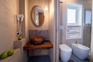 ein Badezimmer mit einem Waschbecken, einem WC und einem Spiegel in der Unterkunft Il Roseto in Sorrent