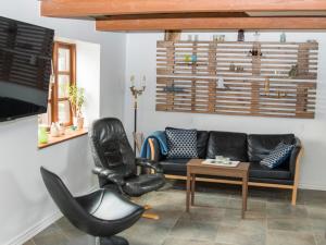 ein Wohnzimmer mit einem Sofa und einem Stuhl in der Unterkunft Knakkergård in Snedsted