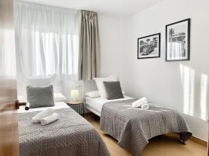 a white room with two beds and a couch at Sofía Suites in Cambrils