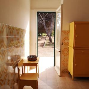 Zimmer mit einem Tisch und einer Tür zum Hof in der Unterkunft Villa Aurora in Capilungo