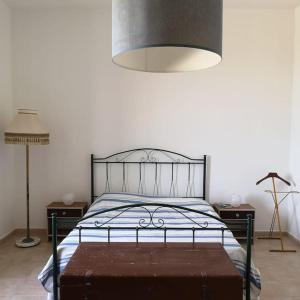 ein Schlafzimmer mit einem Bett mit Metallrahmen und einer Lampe in der Unterkunft Villa Aurora in Capilungo