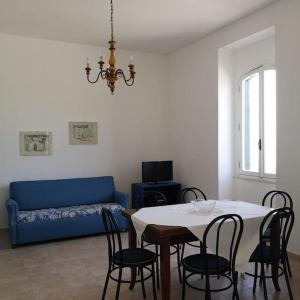 ein Wohnzimmer mit einem Tisch, Stühlen und einem Sofa in der Unterkunft Villa Aurora in Capilungo
