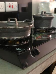 einen Herd mit einer Pfanne darüber in der Unterkunft Andyhill Studio Apartment -Tsavo Embakasi Near Sgr in Nairobi