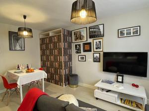 sala de estar con TV, mesa y sofá en Neverending Loft, en Málaga