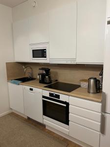 a kitchen with white cabinets and a stove top oven at Cozy centre apartament Kuopio in Kuopio