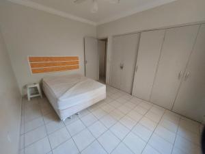 Schlafzimmer mit einem Bett und Schränken in der Unterkunft Lindo apartamento 50 metros da praia do morro, três quartos e duas vagas de garagem in Guarapari