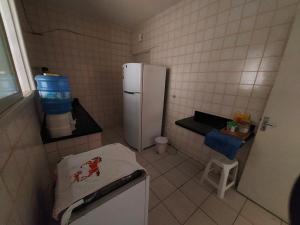 eine kleine Küche mit einem Kühlschrank und einem Stuhl in der Unterkunft Lindo apartamento 50 metros da praia do morro, três quartos e duas vagas de garagem in Guarapari