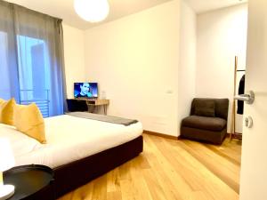 1 dormitorio con 1 cama, 1 silla y TV en Palazzina B - Smart Rooms, en Génova