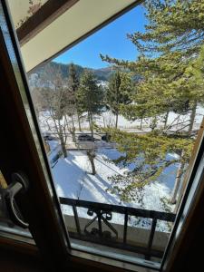 Aussicht aus einem Fenster auf einen schneebedeckten Hof in der Unterkunft Roccaraso Inn Blu in Roccaraso