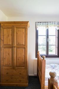 Rýchorská bouda في جاتسلير: غرفة نوم مع خزانة خشبية بجوار سرير