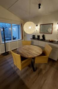 a dining room with a wooden table and yellow chairs at Vakantiehuis Amber in Simpelveld