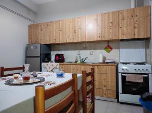 uma cozinha com armários de madeira e uma mesa com mesa; em Aspa's house em Kalabaka