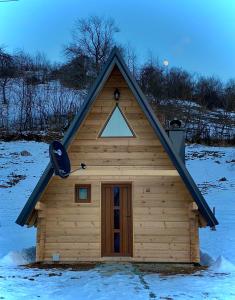 une petite maison avec un toit triangulaire dans la neige dans l'établissement BB CHALET, à Kolašin