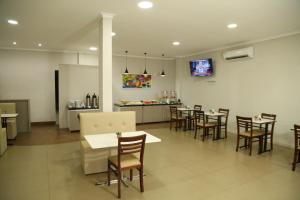 a restaurant with tables and chairs and a counter at Prata Hotel in Santarém
