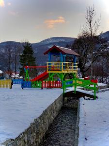 un parque infantil en la nieve con una estructura de juegos en BB CHALET, en Kolašin
