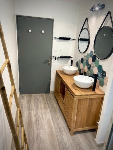 a bathroom with two sinks and a mirror at Le Bon'Appart in Saint-Gilles les Bains