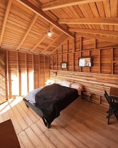 1 dormitorio con 1 cama grande en una habitación de madera en Cabañas Campestres El Naranjo, en San Cristóbal de Las Casas