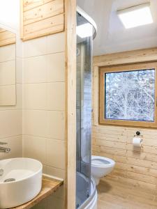 a bathroom with a sink and a toilet and a window at Klimatyczna Chatka u Podnóża Góry in Porąbka