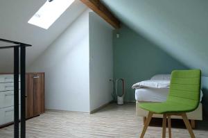 een slaapkamer met een groene stoel naast een bed bij Hoff's Ziegenhof 