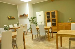 comedor con mesas de madera y sillas blancas en Hoff's Ziegenhof, 