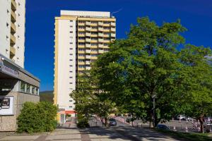 een hoog wit gebouw met een boom ervoor bij App 365 Panoramic Hohegeiß mit WLan in Braunlage