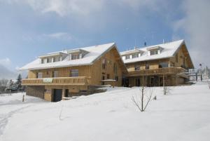 uma grande casa de madeira com neve em cima em Apartmán Perník Kvilda em Kvilda