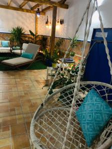 eine Schaukel auf einer Terrasse mit einem Tisch und Stühlen in der Unterkunft Casa Pepita Gutiérrez in Sevilla