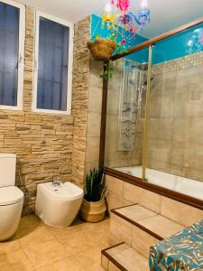 a bathroom with a tub and a toilet and a sink at Casa Pepita Gutiérrez in Seville