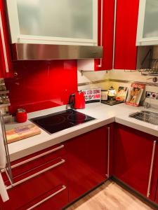 a kitchen with red cabinets and a stove top oven at Casa Pepita Gutiérrez in Seville