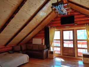 sypialnia w drewnianym domku z łóżkiem i telewizorem w obiekcie Шале Гірська Казка w Jaremczach