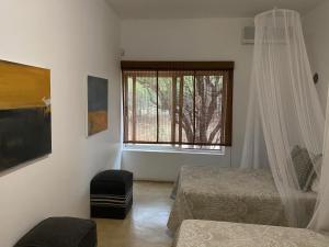 1 dormitorio con 2 camas y ventana en Birdsong Kruger, en Marloth Park