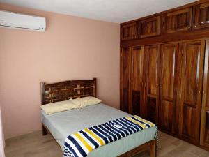 1 dormitorio con 1 cama y armarios de madera en Playa Azul, Michoacán Casa&SolMarena en Playa Azul