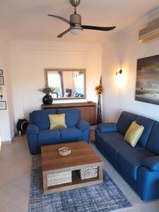a living room with blue couches and a coffee table at Fairviews Villa on Boavista Golf Resort in Lagos