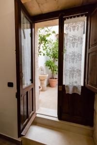 an open door leading to a bathroom with a plant at Appartamenti Vittoria in Syracuse