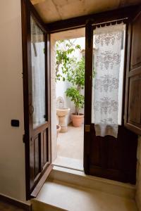 シラクーサにあるAppartamenti Vittoriaの植物のあるバスルームにつながる開放ドア