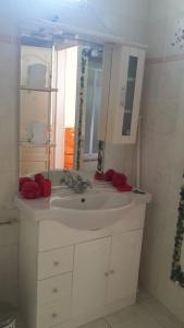 y baño con lavabo blanco y espejo. en Résidence rose Cannelle, en Grand-Bourg