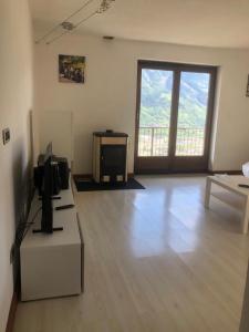 a living room with a large window and a television at Villa Sole in Aosta