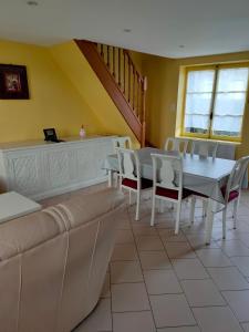 a dining room with a couch and a table and chairs at Gîte Caribou in Céaux