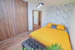 um quarto com uma cama amarela e um armário de madeira em Apartament na Zlotej Podkowie em Glogów