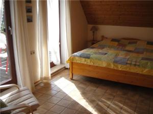 a bedroom with a bed and a chair and a window at Ferienwohnung-Strandkorb in Ulsnis