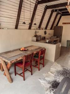 a kitchen with a wooden table and some chairs at Shepherds Rest in Hoedspruit +17 photos
