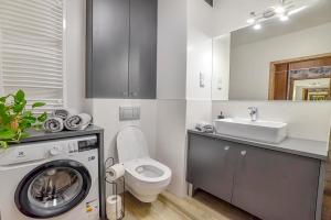 ein Badezimmer mit einer Waschmaschine und einem Waschbecken in der Unterkunft Apartament na Zlotej Podkowie in Głogów
