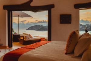 a bedroom with a bed and a view of the ocean at Espuma Hotel - Adults Only in Zihuatanejo