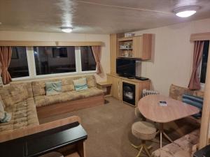 ein Wohnzimmer mit einem Sofa und einem Tisch in der Unterkunft Meadow Lakes 39 in Skegness