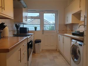 kuchnia z pralką i suszarką oraz okno w obiekcie Stylish 3 Bedroom House with Free Parking w mieście Norwich