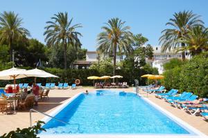 - une piscine avec des chaises, des parasols et des chaises dans l'établissement Hotel Luxor, à Playa de Palma