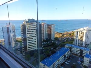 a view of a city with the ocean and buildings at Departamento full a pasos de la playa in Viña del Mar