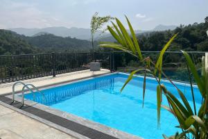 a swimming pool with mountains in the background at Rivendell Hotel in Kandy