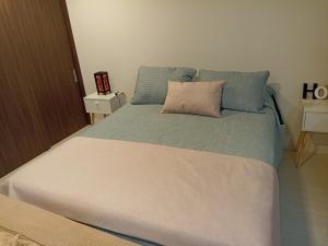 Un dormitorio con una cama grande con una almohada. en Departamento full a pasos de la playa, en Viña del Mar