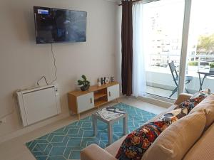 a living room with a couch and a tv at Departamento full a pasos de la playa in Viña del Mar